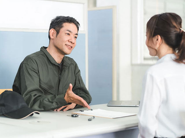 整備士の説明を聞いている女性