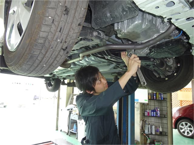 車の下を点検、整備をしている整備士
